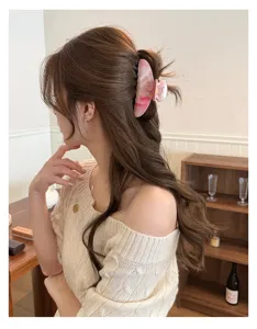 Detailed shot of a pink marbled crescent hair claw clip, elegant updo hair accessory for women.