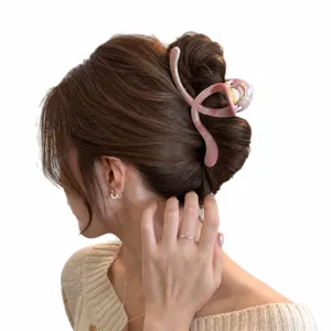Pink crescent moon hair claw clip for women, elegant marbled hollow hair styling accessory.