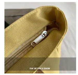 Nahaufnahme des gelben Canvas Tragetasche Reißverschlusses mit Metallteilen und feinen Nähten.