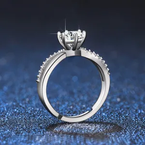 Close-up of a glittering six-prong moissanite ring with a sparkling crossover paved band.