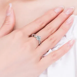 Detail of the moissanite cross ring, showing six-prong solitaire and sparkling pavé stones.