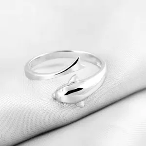 Close-up detail van de elegante dolfijn open zilveren ring, gepolijste textuur.