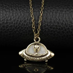 Detailed close-up of the antique bronze UFO alien spaceship pendant necklace glowing.