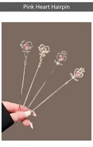 Primo piano dettagliato del bastoncino per capelli magico con cristallo cuore rosa e ali.
