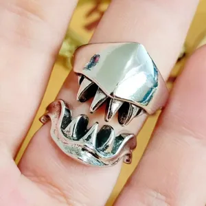 Close-up detail of silver punk monster teeth open ring, cool edgy statement jewelry for men.