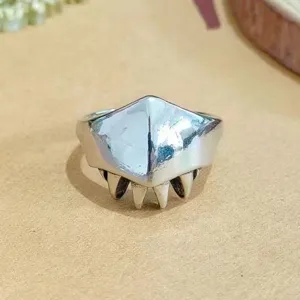 Close-up detail of the edgy punk style metallic ring featuring sharp teeth and mask design.