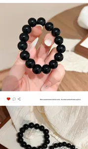 Bracciale con perline di vetro nero imitazione ossidiana, consistenza liscia e lucida, gioiello elegante.