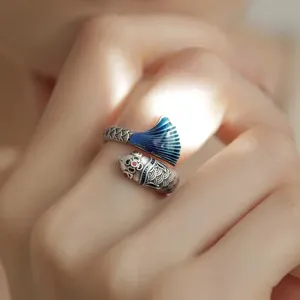 Primer plano del anillo koi de esmalte retro con la cola azul delicada y textura detallada.