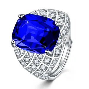 Dettaglio ravvicinato della gemma blu scuro taglio cuscino e anello largo in argento.