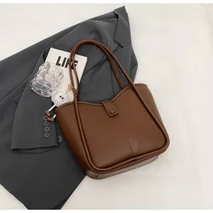 Dettaglio della borsa tote marrone in stile retrò con grande capienza per il lavoro.