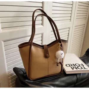 Vista dettagliata della borsa tote rétro bicolore con ciondolo soffice per lavoro