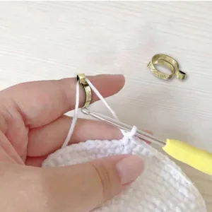 Adjustable crochet tension ring for knitting and yarn guiding, metal finger ring accessory.