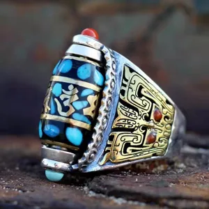 Gros plan détaillé d'une bague vintage tibétaine avec perle dzi, turquoise et motifs de dragon.