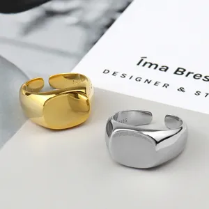 Minimalist geometric square open ring in gold and silver, sleek modern jewelry detail.