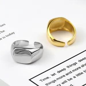 Minimalist geometric square open ring detail, showing sleek silver and gold metal texture.