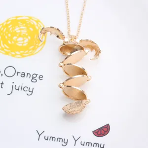 Vue détaillée du pendentif collier reliquaire à ailes multicouches ouvrant en or brillant.