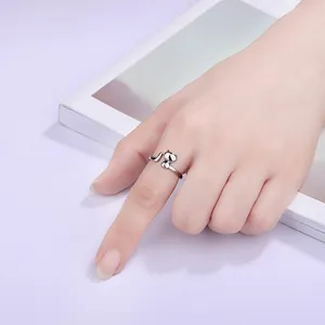 Detailaufnahme eines süßen offenen silbernen Katzenrings am Finger mit feinen Katzenohren.