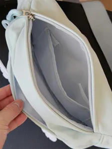 Detailed interior view of light green crossbody chest bag with zipper pockets and compartments.