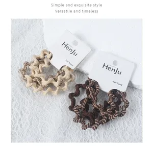 Close-up detail of vintage wavy hair bands in beige and dark brown, showcasing fine texture.