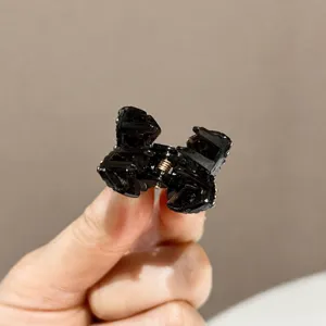 Mini pince à cheveux papillon noire avec strass pour coiffure élégante et style de cheveux latéraux.