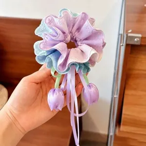 Vue rapprochée d'un chouchou violet dégradé aux jolies bandes de pendentifs tulipes.