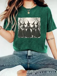 Close-up detail view of the dark green graphic t-shirt featuring a vintage witch illustration.