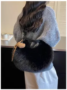 Detail du sac bandouliere en fausse fourrure noire, sac peluche sous les bras hiver.