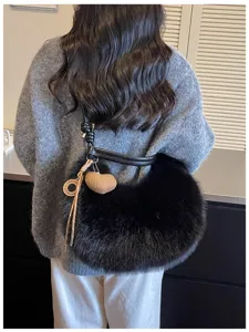 Détail du sac porté épaule en peluche noire avec fausse fourrure douce et lanière élégante.