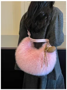 Vue détaillée du sac porté épaule hobo en fausse fourrure rose à texture pelucheuse.