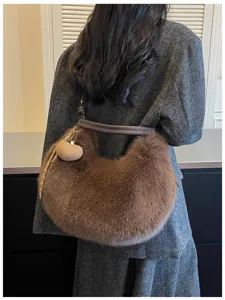 Vue détaillée du sac à bandoulière en peluche marron élégant avec charm, accessoire chaud.