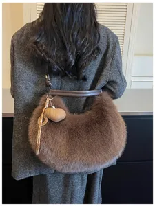 Vue détaillée d'un sac porté épaule moelleux en fausse fourrure marron avec lanière en cuir.