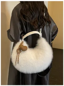 Vue détaillée d'un sac à épaule moelleux en fausse fourrure blanche avec pendentif cœur en tricot.