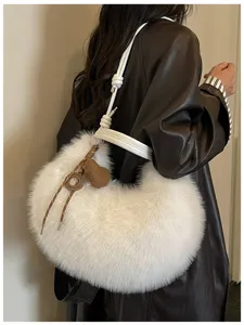 Vue détaillée d'un sac porté épaule duveteux blanc avec pendentif cœur en tricot.