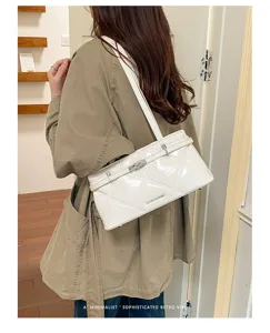 White quilted leather shoulder bag with metallic lock, elegant minimalist underarm design.