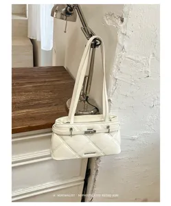 White quilted bag detail showing soft leather, elegant diamond stitching and sleek metallic lock.