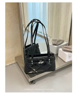 Detail view of black quilted leather shoulder bag with metal lock and dual straps for women.