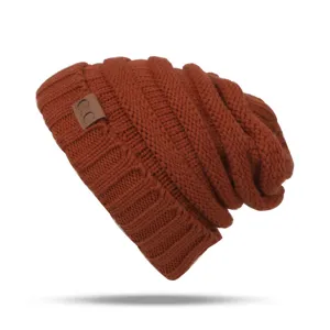 Close-up detail of the rust brown winter knitted slouchy beanie hat with leather patch.