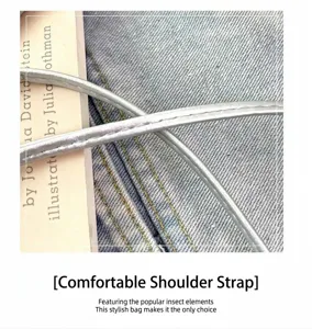 Detaillierte Ansicht des stylischen silbernen Schulterriemens mit Jeansstofftextur.