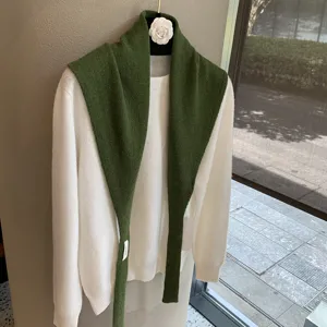 Green knitted shawl paired with white sweater, stylish fall winter layering top for women.