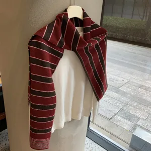 Detailansicht des koreanischen gestreiften Strickschals ueber einem weissen Pullover.