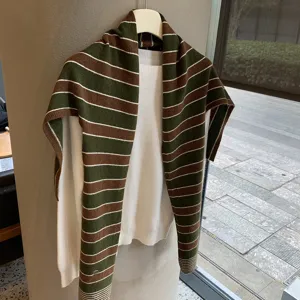 Detailansicht des koreanischen gestreiften Strickschals ueber weissem Pullover fuer Damen.