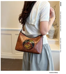 Sac bandoulière en cuir motif floral rétro, sac porté épaule pour femme vue détail.