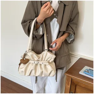 Vue détaillée de l'élégant sac porté épaule plissé avec boucle et charmant pendentif cœur.