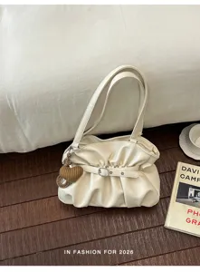 Vue détaillée d'un sac porté épaule plissé crème chic avec charm cœur et boucle en métal.