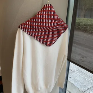 Detailed view of the retro geometric patterned knitted shawl and white sweater combo.