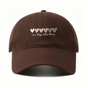 Braune Baseballkappe mit Herz-Print und Spruch, stylischer Freizeithut für Damen und Herren.