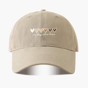 Klassische beige Baseballcap mit Herzen Aufdruck und inspirierendem Text für den Alltag.