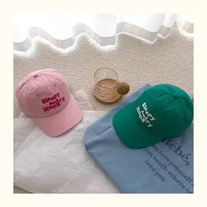 Nahaufnahme Details niedlicher bestickter Baumwoll Baseballcaps in Rosa und Grün Sommer.