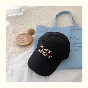 Detailansicht der schwarzen bestickten Baseballkappe mit bunter Schrift und Freizeitsstil.