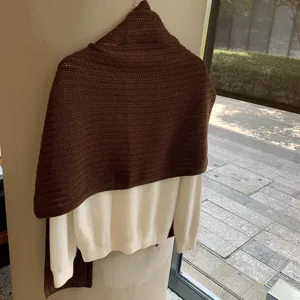 Vista detallada chal de punto marrón y jersey blanco en capas, moda cómoda de otoño invierno